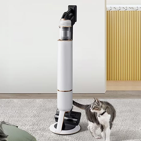 white handstick vacuum with a cat twirling beside it